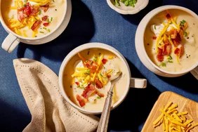 Bowl of potato soup with cheese and bacon garnish