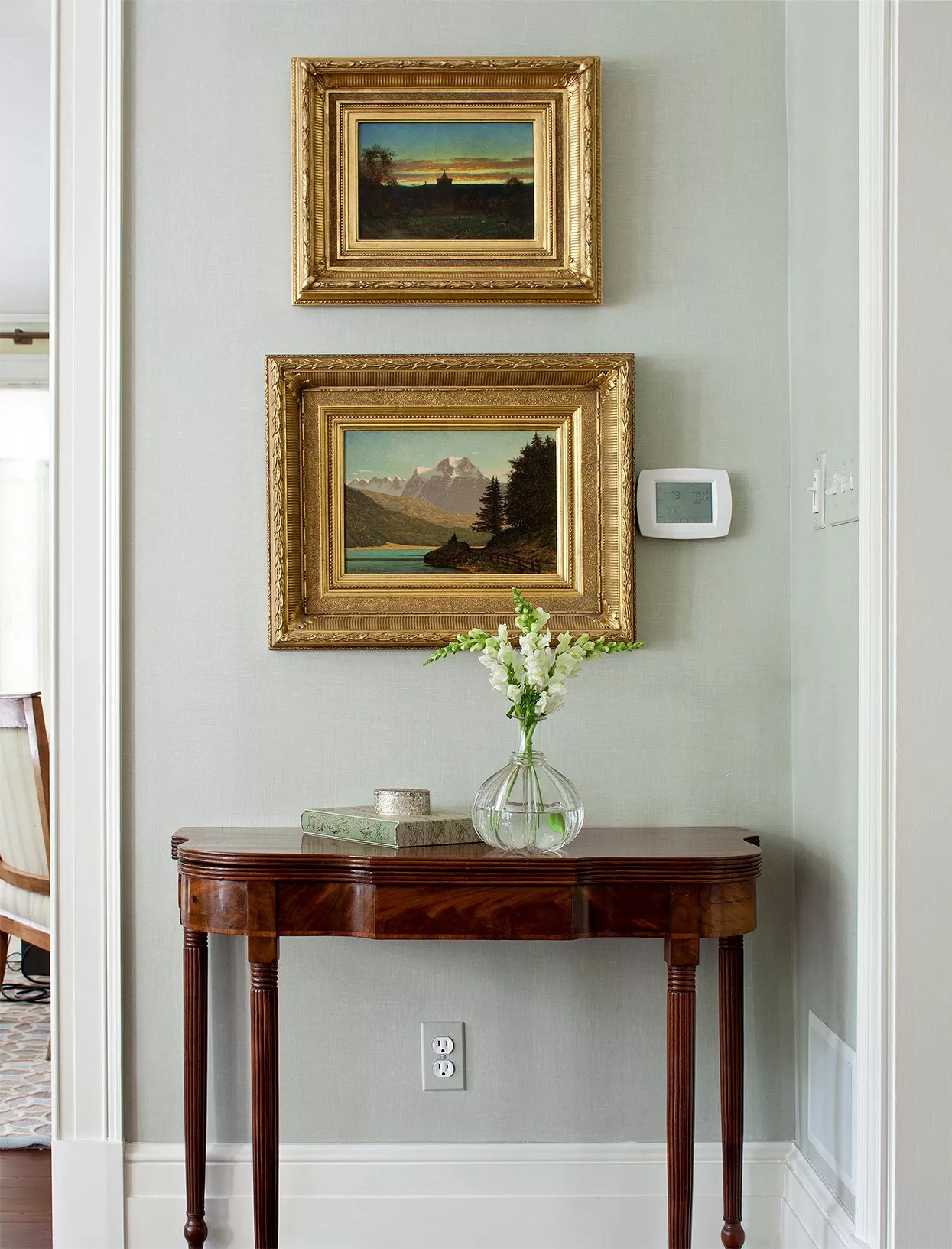 vintage accent table below gold ornate frames