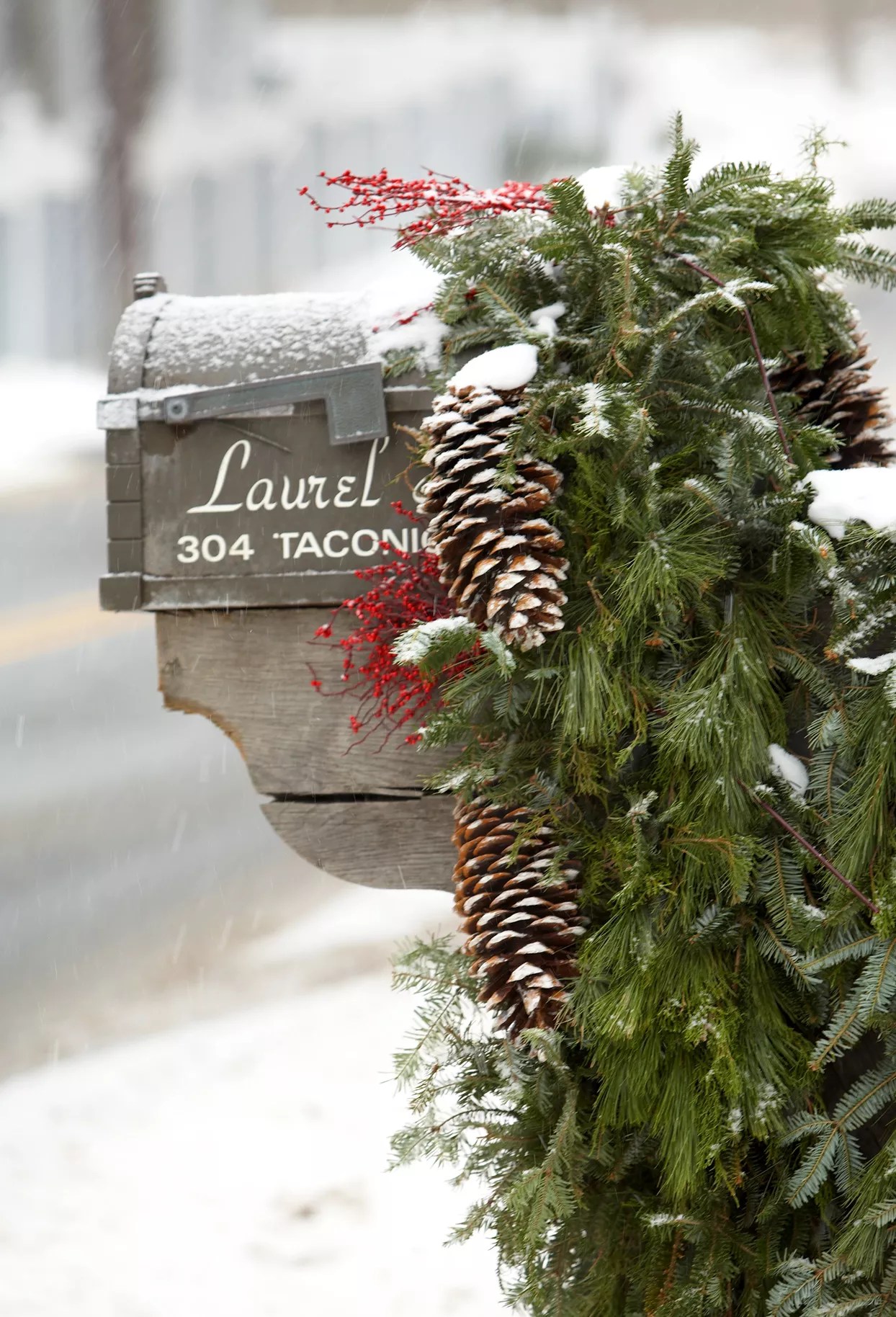 snowy mailbox decorated with holiday garland