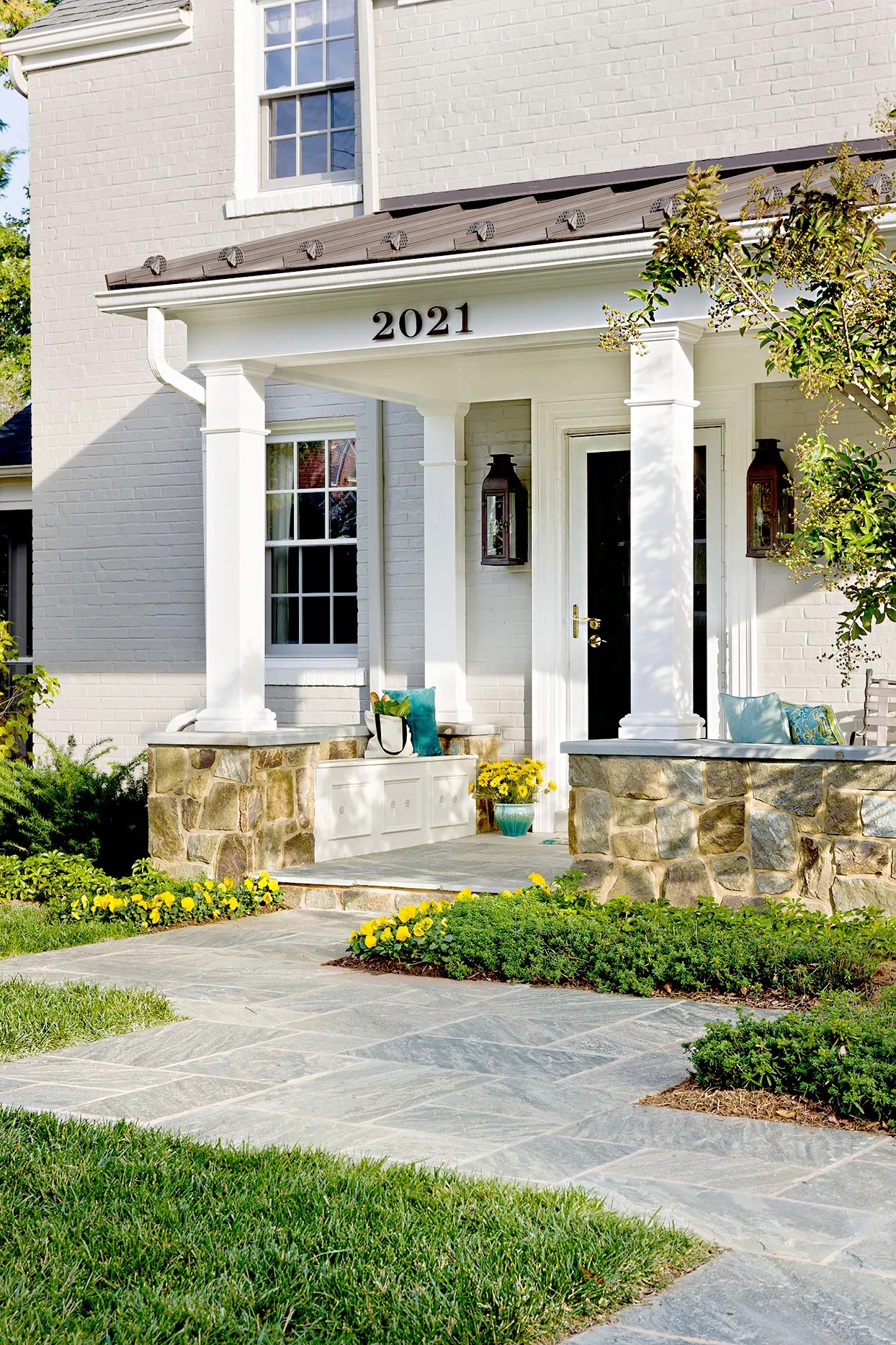 Front entryway with pillars and stone walkway