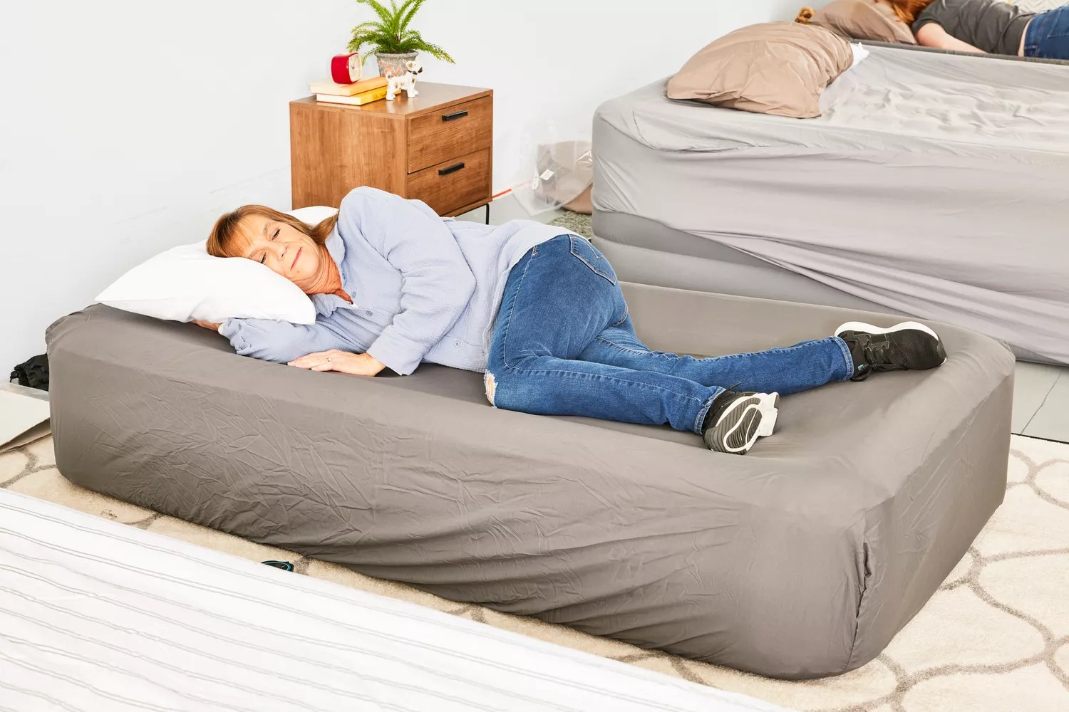 A person lies on the Coleman SupportRest Double-High Rechargeable Air Mattress