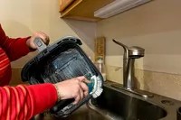 A person washes the Cosori TurboBlaze 6-Quart Air Fryer in a sink