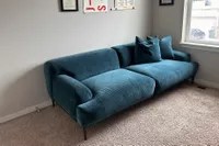 The Article Abisko Sofa in the corner of a room on a carpet
