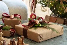 gifts wrapped in brown paper by christmas tree