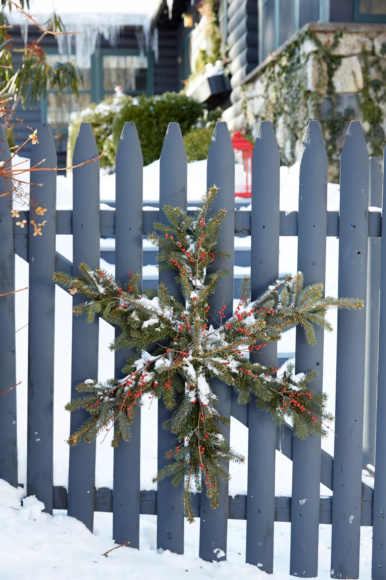 Pine wreath cut into the shape of a snowflake hanging on a fence