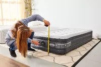 A person measures the Coleman SupportRest Double-High Rechargeable Air Mattress