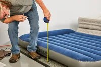 A person measures the height of the Bestway Tritech Air Mattress with Built-in Pump
