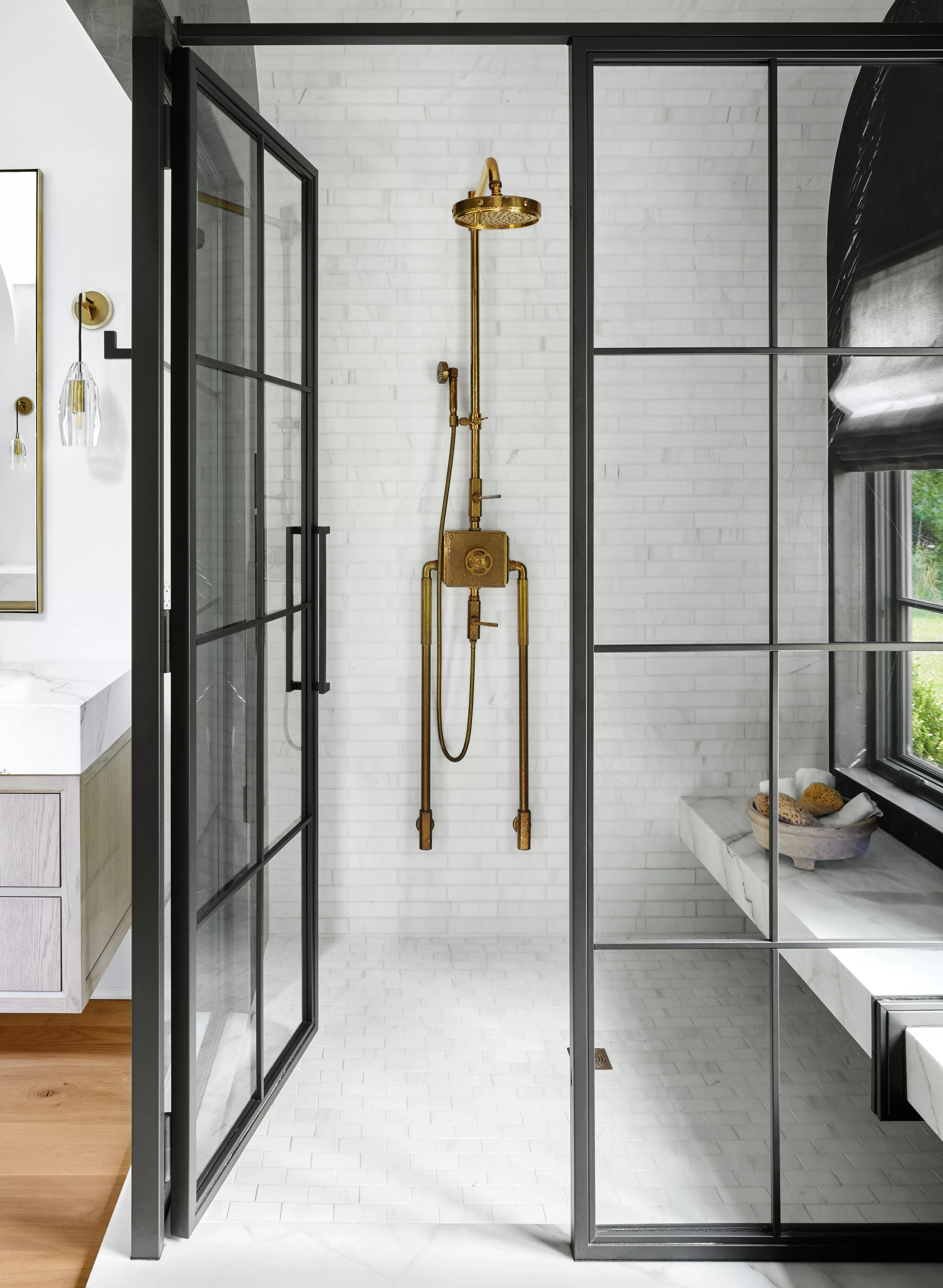 bathroom shower with glass doors and brass showerhead