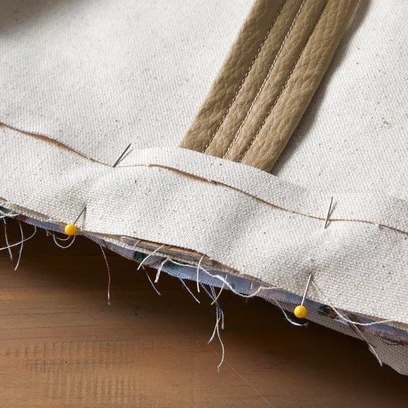 close-up canvas strip pinned over sewn leather strap