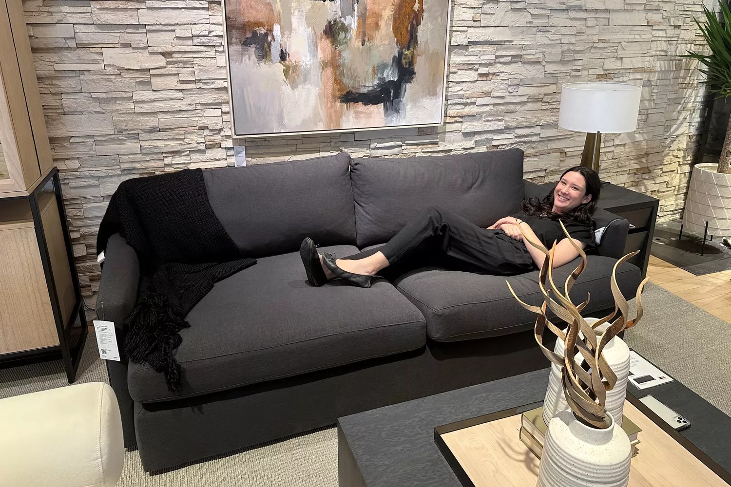 A person sits on the Crate&amp;Barrel Lounge Deep Sofa