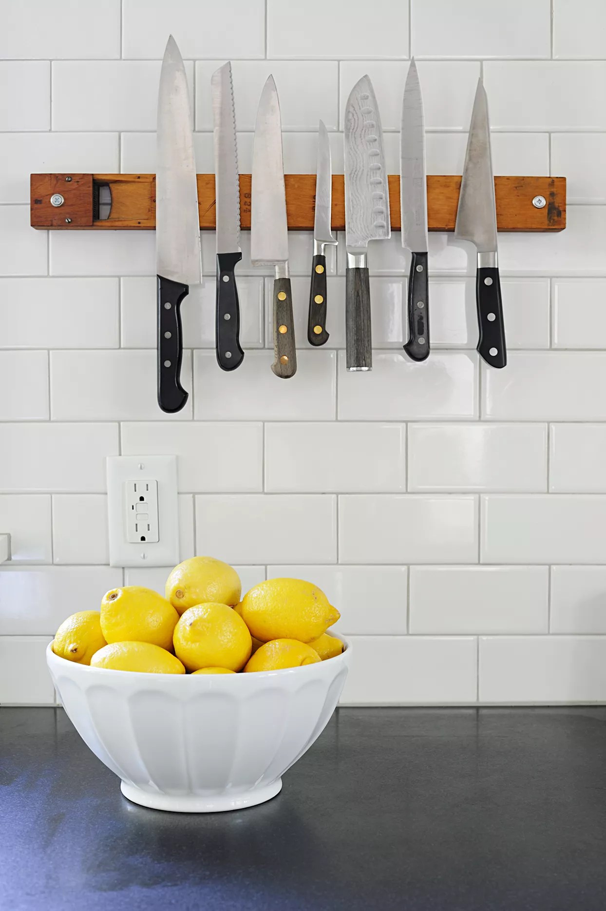 bowls of lemon on counter in front of light socket and knives