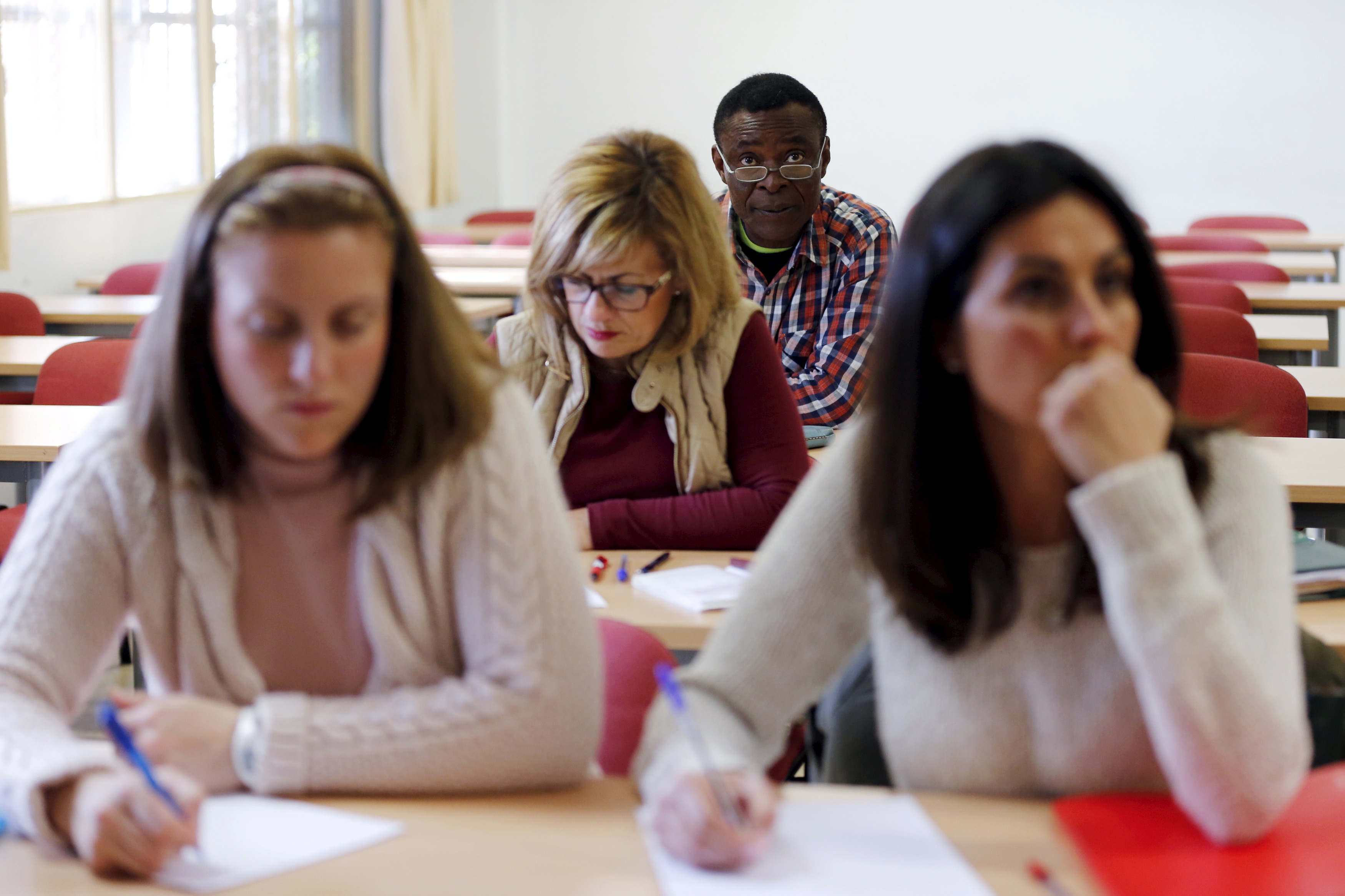 Howard Jackson, a Liberian migrant, attends a law class at a university in the Andalusian capital of Seville, southern Spain March 8, 2016. Jackson escaped civil war and spent three years crossing Africa before reaching Spain. Dressed up in one of his more than 200 costumes, from Peter Pan to Little Red Riding Hood, he is a well-known figure at an intersection entering the Spanish city of Seville where he has sold tissues to motorists for over a decade. Jackson is studying law and wants to become a judge. REUTERS/Marcelo del Pozo SEARCH "MIGRANT JACKSON" FOR THIS STORY. SEARCH "THE WIDER IMAGE" FOR ALL STORIES - GF10000350822