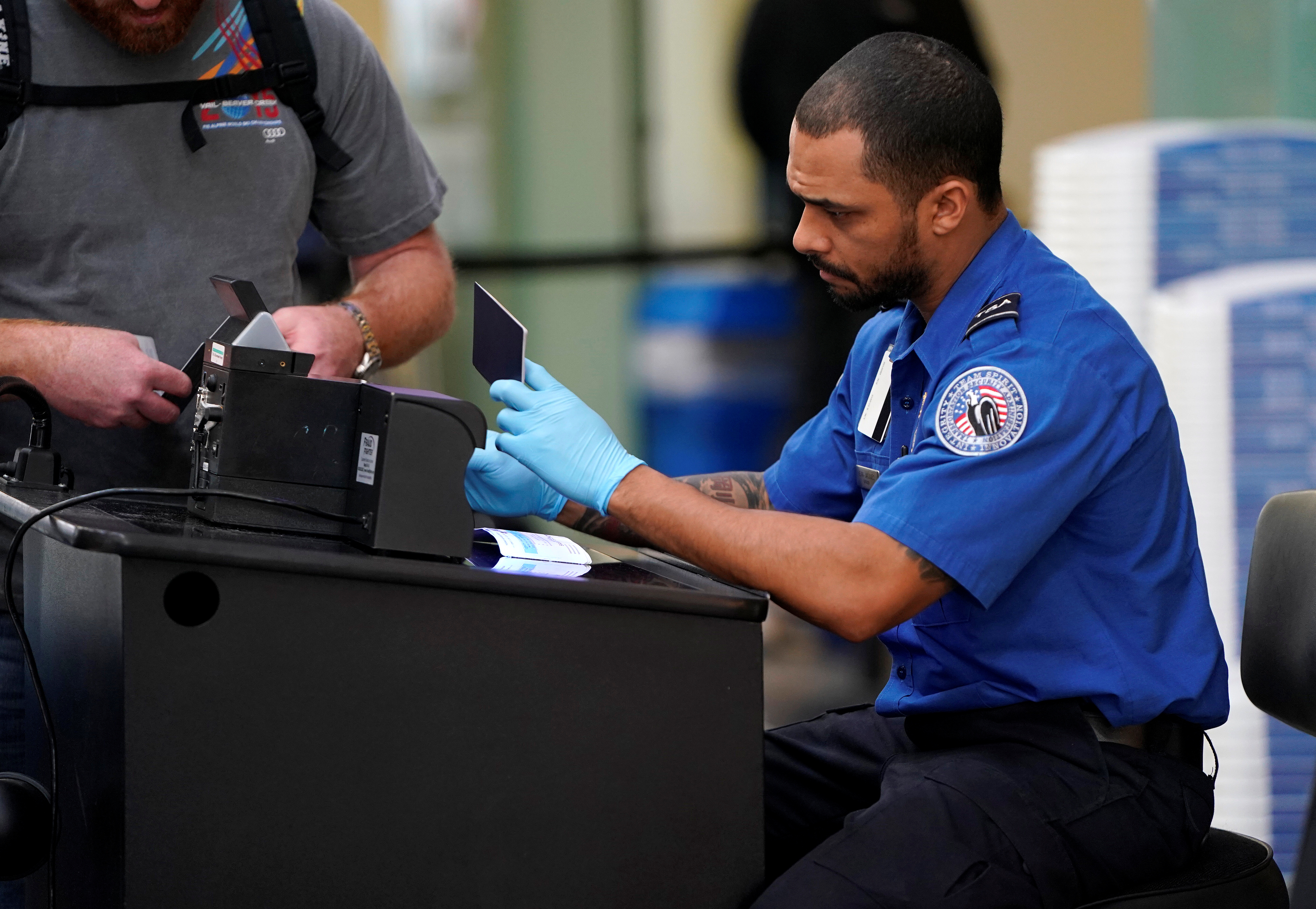 An employee with the Transportation Security Administration (TSA) checks the documents of a traveler at Reagan National Airport in Washington, U.S., January 6, 2019. REUTERS/Joshua Roberts - RC1299538A70