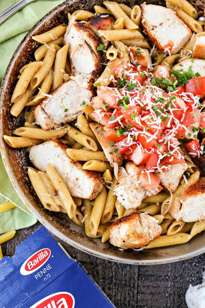 Bowl of Cajun Chicken Pasta topped with tomatoes and cheese