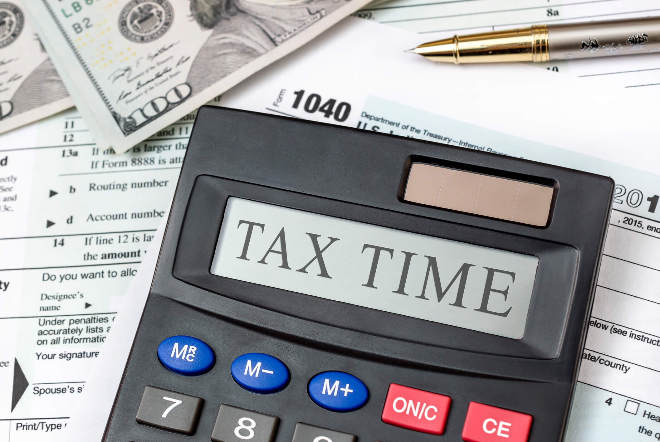 Calculator with text “Tax Time” on tax forms and money. Business