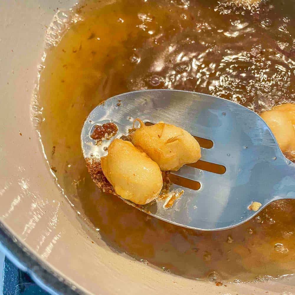 breaded cheese curds being removed from oil