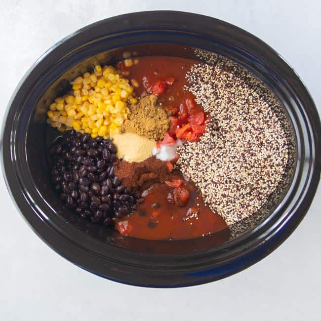 corn, beans, tomatoes, spices and quinoa in slow cooker