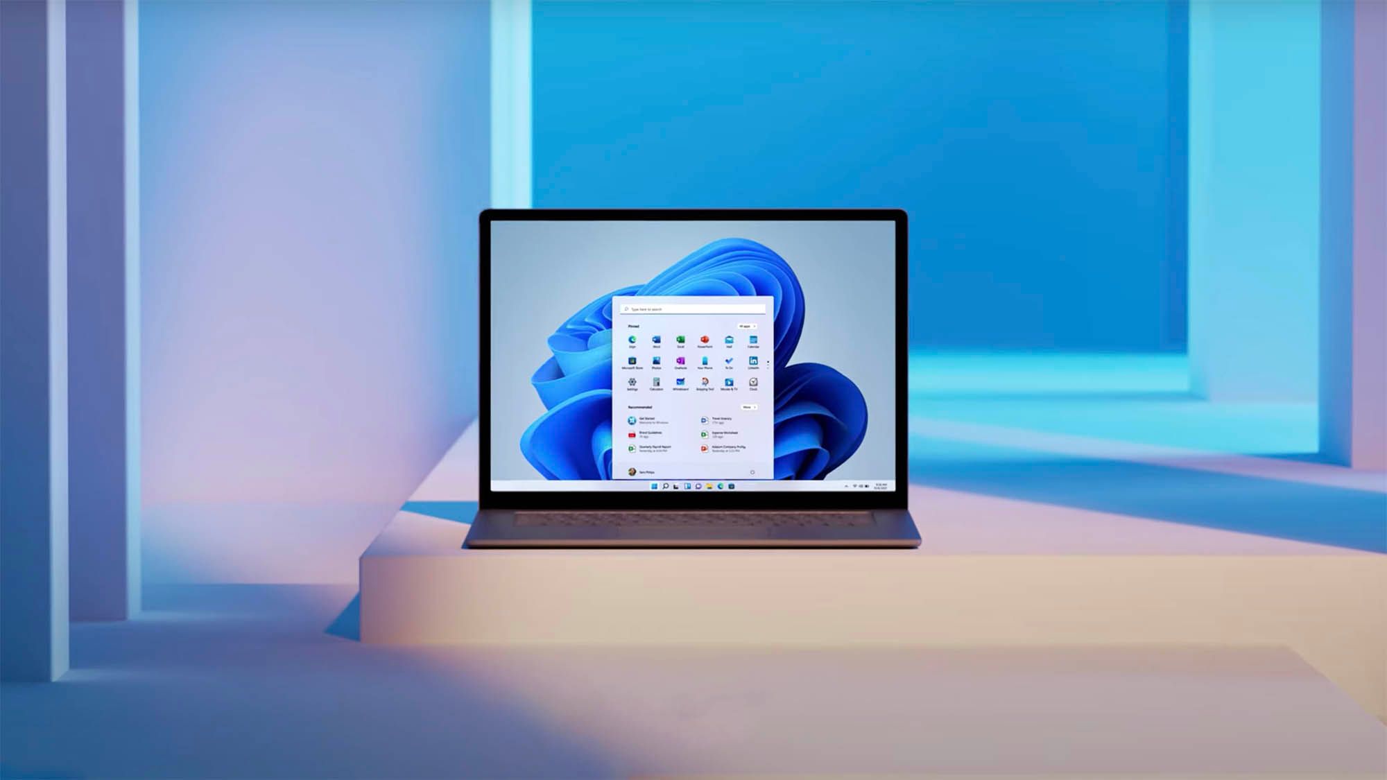 A laptop sits on a white step, surrounded by white and blue lighting. It&rsquo;s running Windows 11.