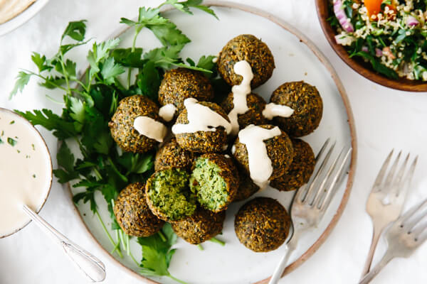 A plate of falafel drizzled with tahini sauce.