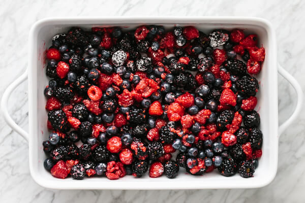 Berry filling in a single layer in a baking pan.