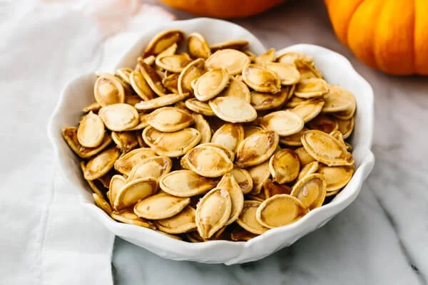 A bowl with roasted pumpkins seeds.