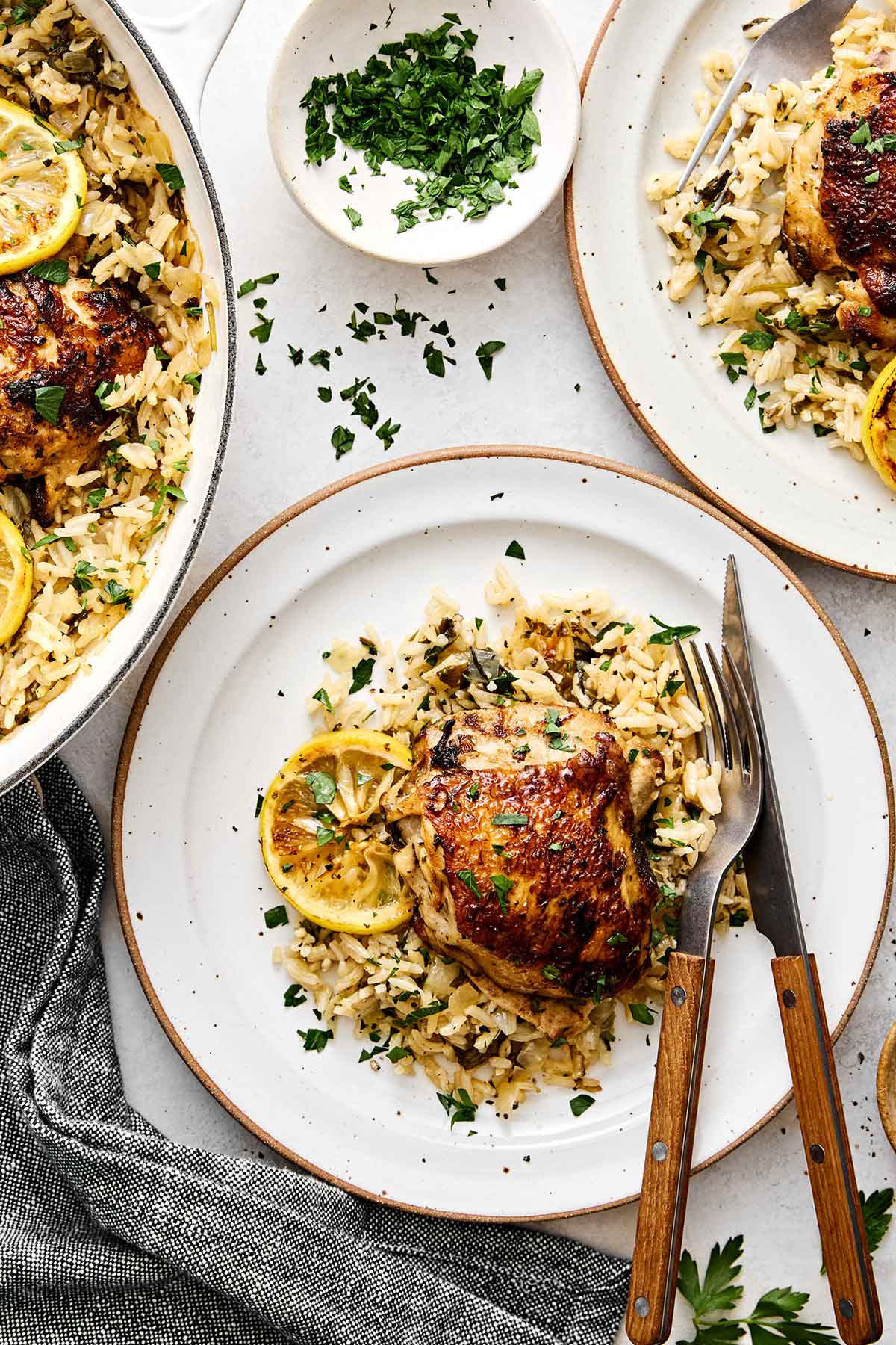 This chicken and rice is an easy, one-pan weeknight dinner I can always depend on. Mediterranean chicken thighs mixed with herby rice! Chicken and rice on plates.