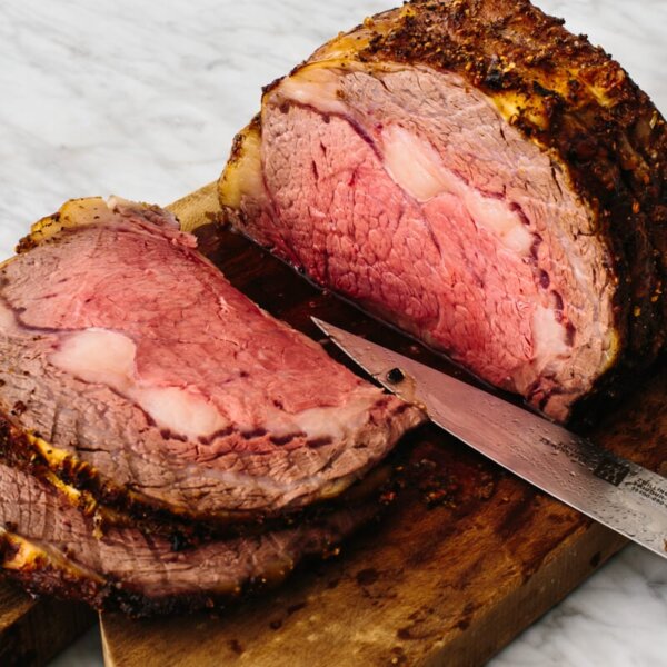 Prime rib sliced on a cutting board.