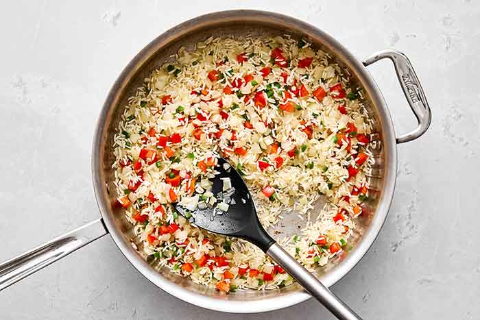 Cooking rice and veggies in a pan for Mexican rice.