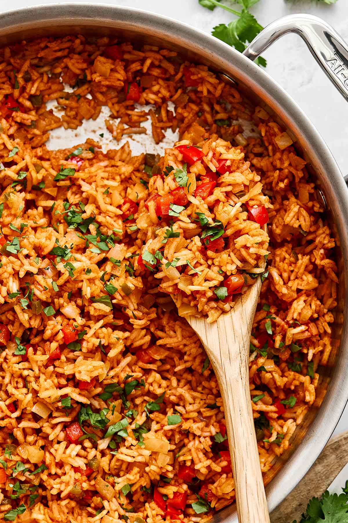 This Mexican rice is the perfect side dish for your dinner spread! It's layered with authentic flavor, really easy to make, and loved by all. Mexican rice in a pan with a spoon.