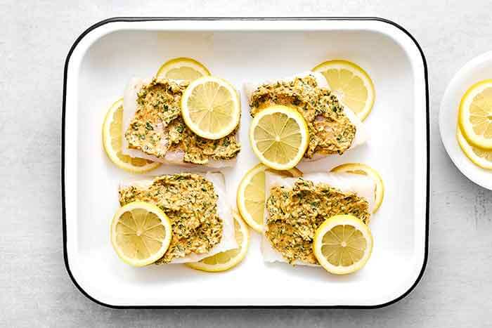 Step four of baked cod: add the lemon slices.