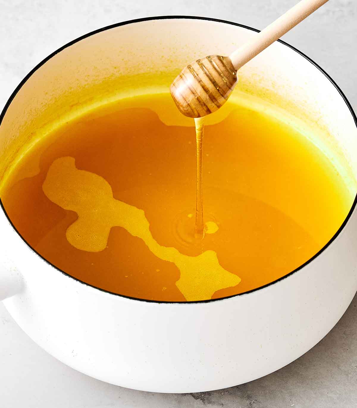 Upgrade your wellness routine with this simple turmeric tea! All you need is ground turmeric, lemon, honey, and black pepper. Second step to making turmeric tea by adding honey after it simmers on the stovetop.