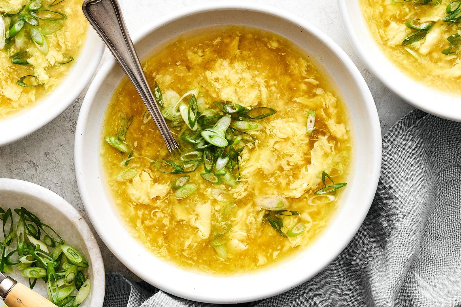 Bowl of egg drop soup and green onion.