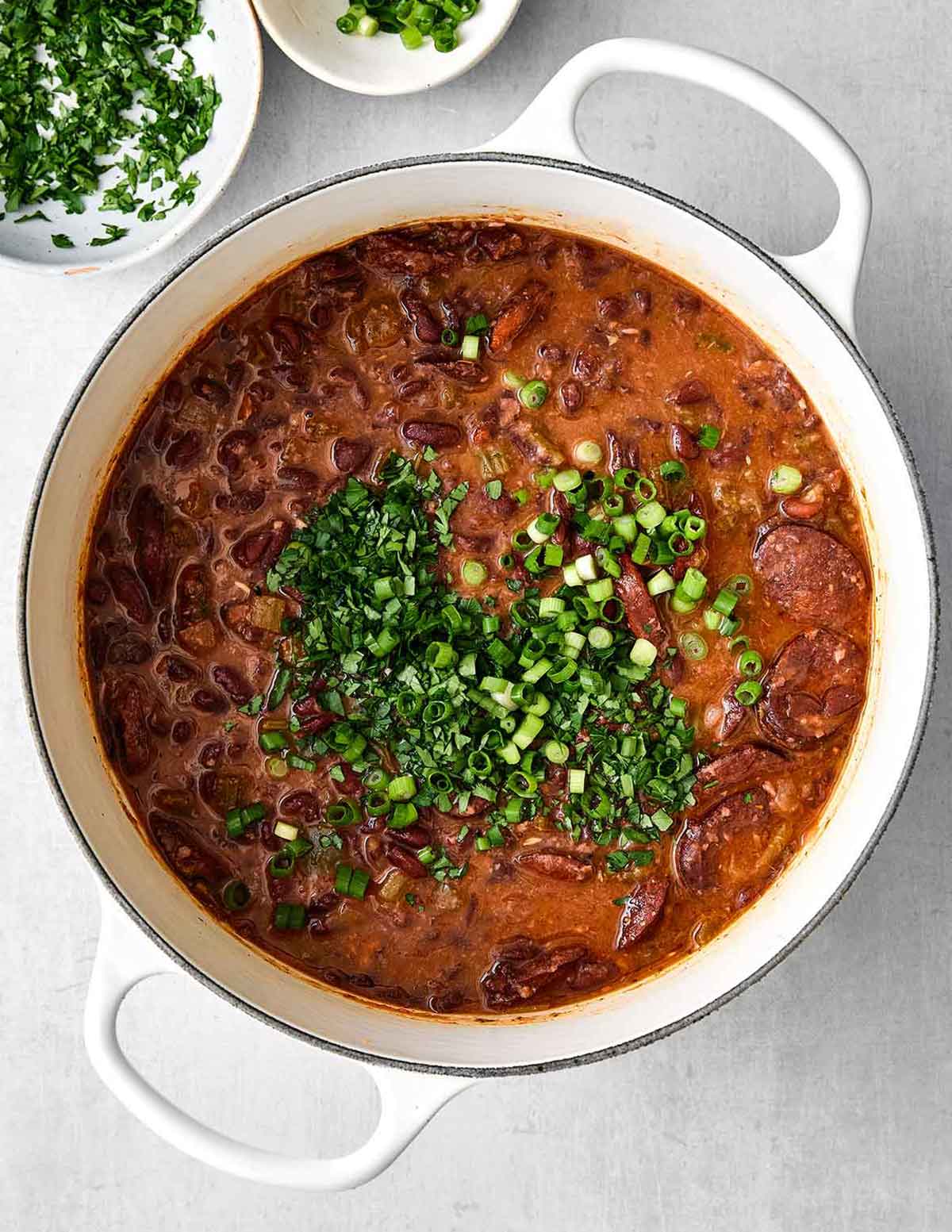 This red beans and rice with sausage is rich with Cajun flavors and perfect for a comforting family dinner. Plus, it's super easy in one pot! Step five of red beans and rice: Add green onion.