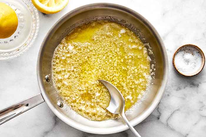 Making lemon garlic butter sauce in a pan.