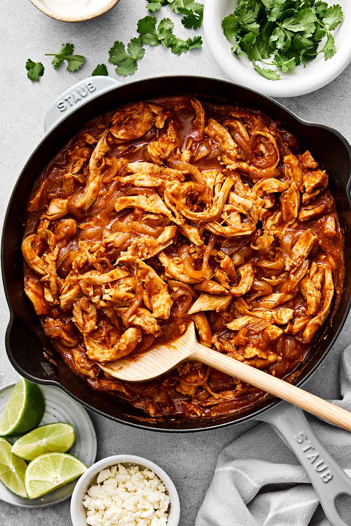 You'll eat this Mexican chicken tinga on repeat! It's made with shredded chicken, a smoky tomato-chipotle sauce, and caramelized onions. Chicken tinga in a pan.