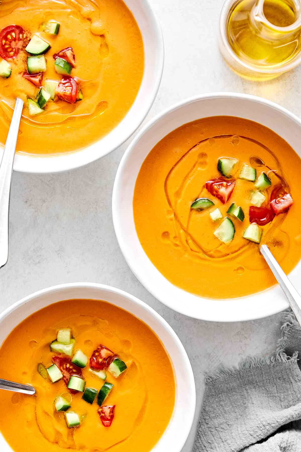 This red gazpacho is the ideal summer soup! It's chilled, creamy, and a great way to make the most of sweet, in-season tomatoes. Bowls of gazpacho with tomatoes.