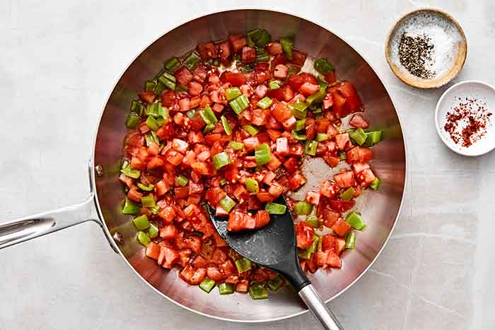 Sauteing veggies in a pan for menemen.