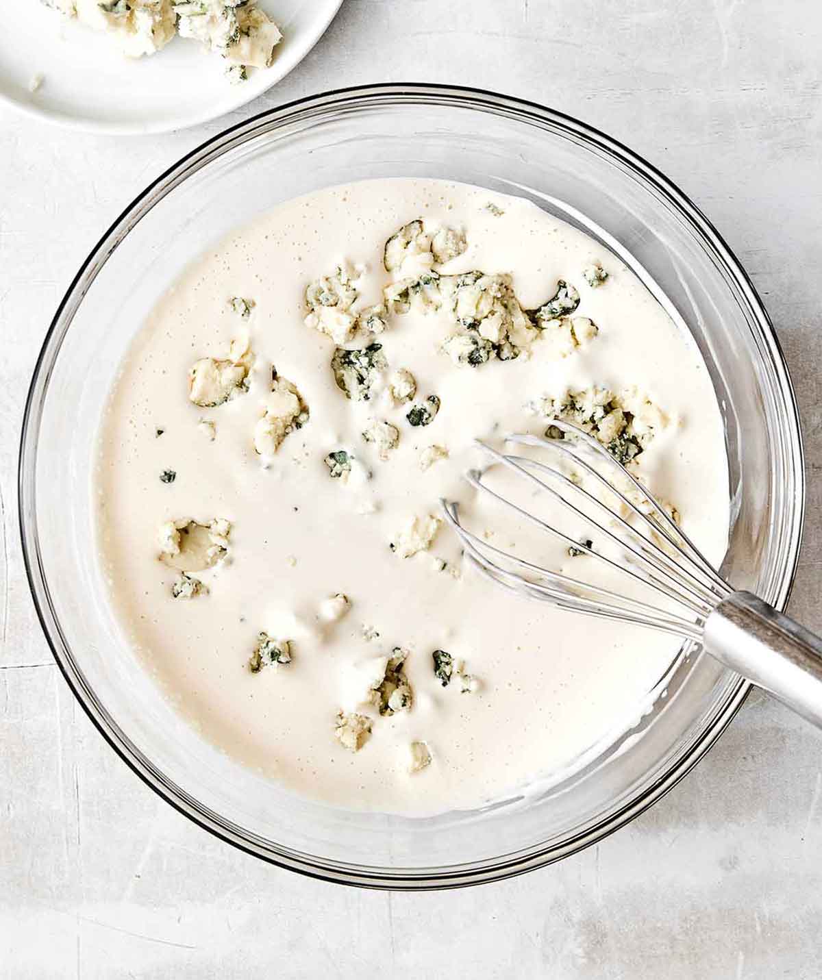 This blue cheese dressing is rich, creamy, tangy, and gives that classic steakhouse flavor perfect for a classic wedge salad. Adding blue cheese into a blue cheese dressing.