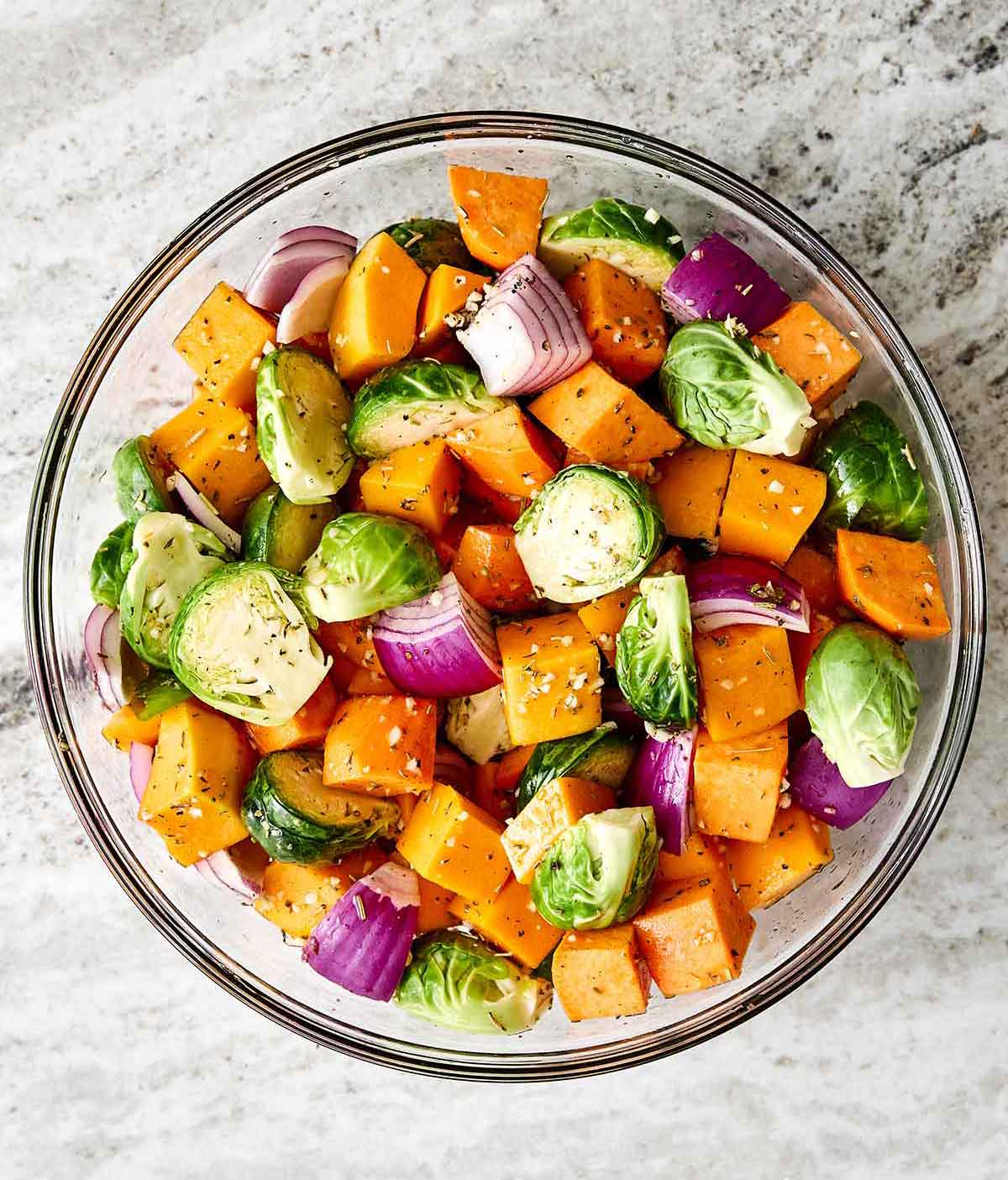 Fall roasted vegetables for the perfect dinner side dish. Tossing fall vegetables in a seasoning.
