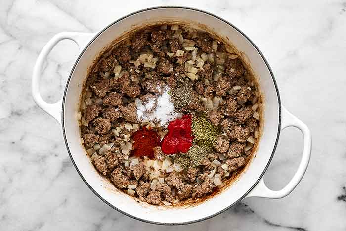 Cooking ground beef with seasoning in a pot.