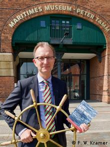 Erik Lindner in front of the Maritime Museum in Hamburg, holding in his hand the SKYLUCK steering wheel (F.W. Kramer)