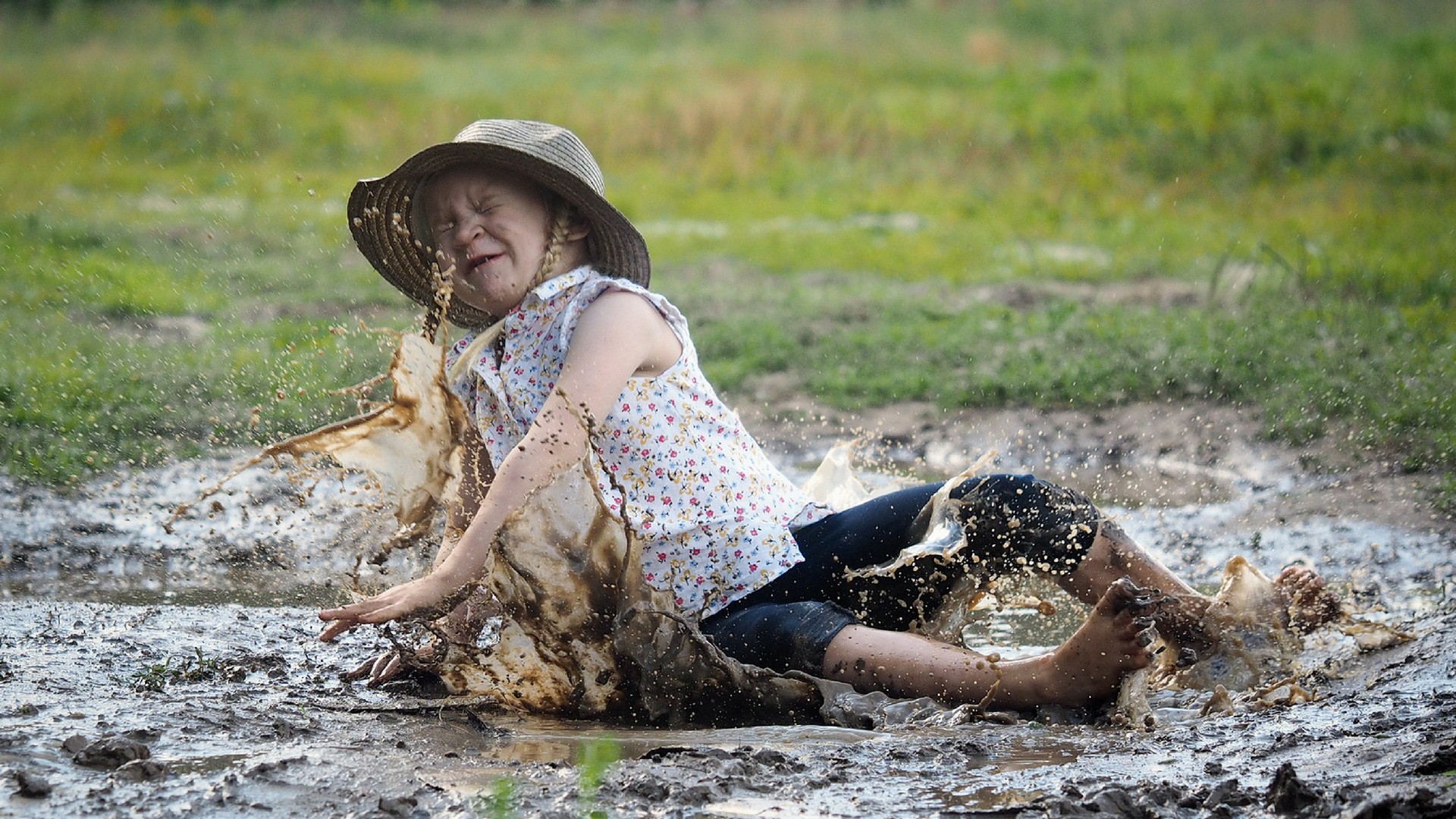 Kleines Mädchen fällt in den Schlamm Echte Mamas