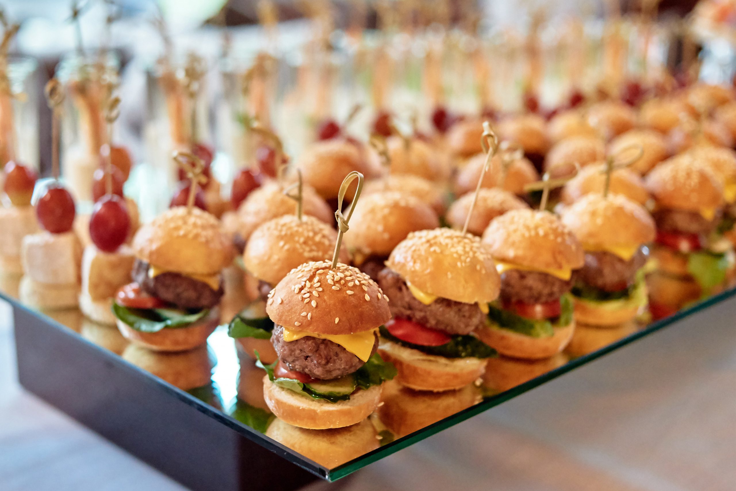 Buffet table with mini hamburgers and canape at luxury wedding reception, copy space. Serving