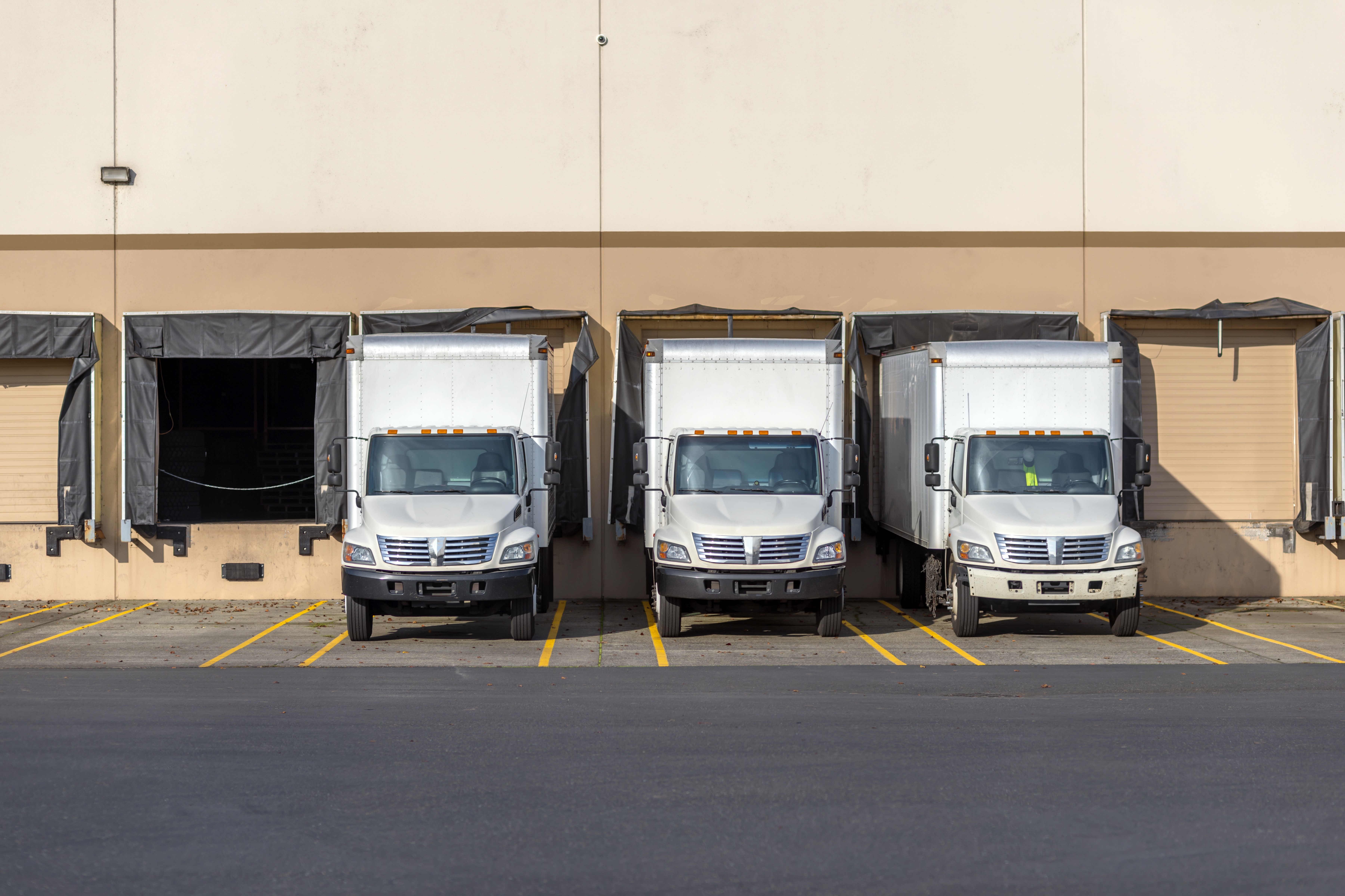 Small compact rigs semi trucks with box trailers standing in row at