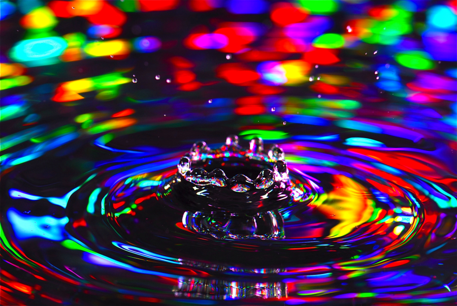 A droplet splashing into a shallow pool forms a crown shape while the