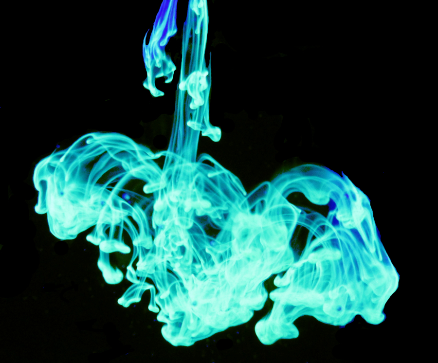 Highligher ink fluoresces under UV light as it falls through water