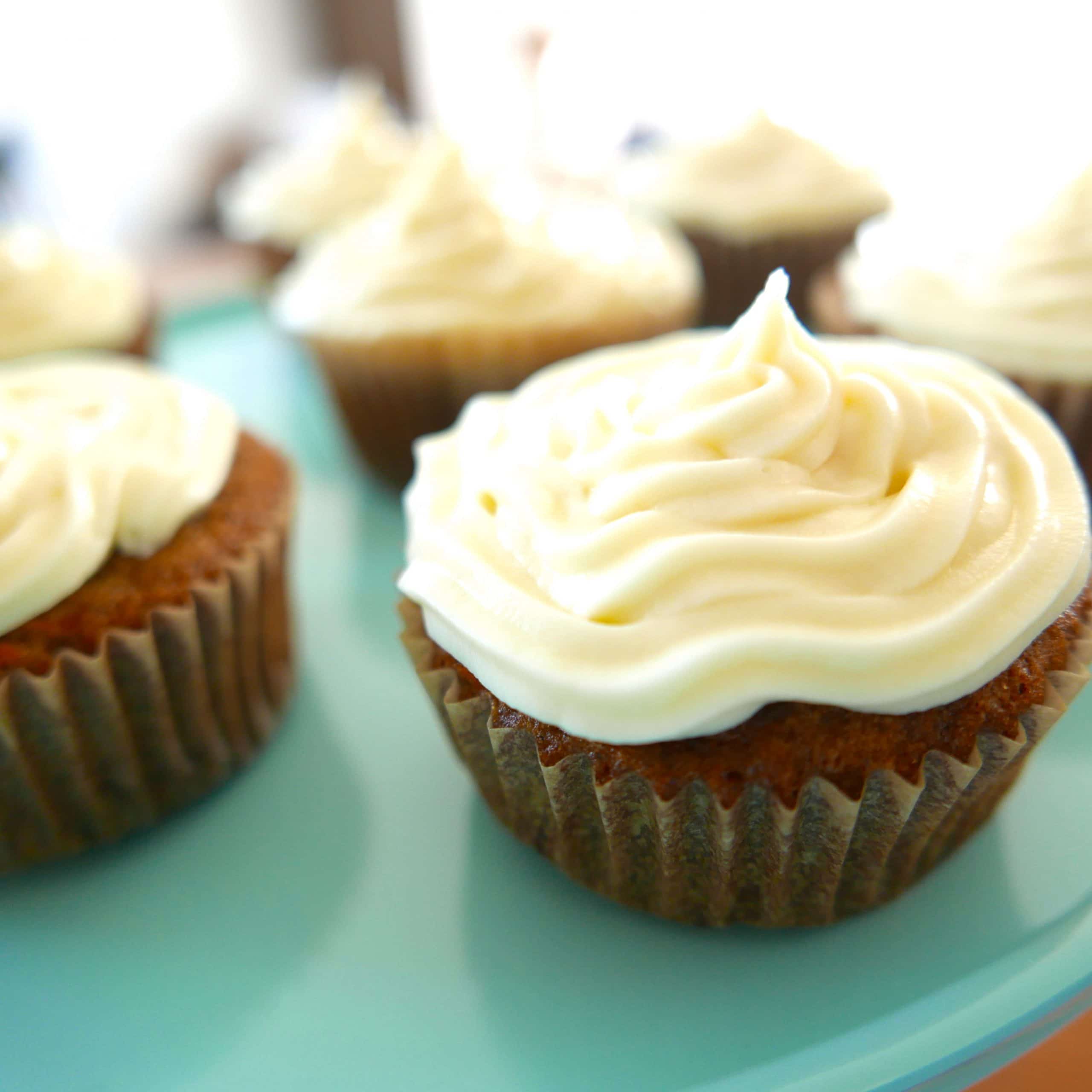 carrot cake cupcakes arranged on a teal cake stand