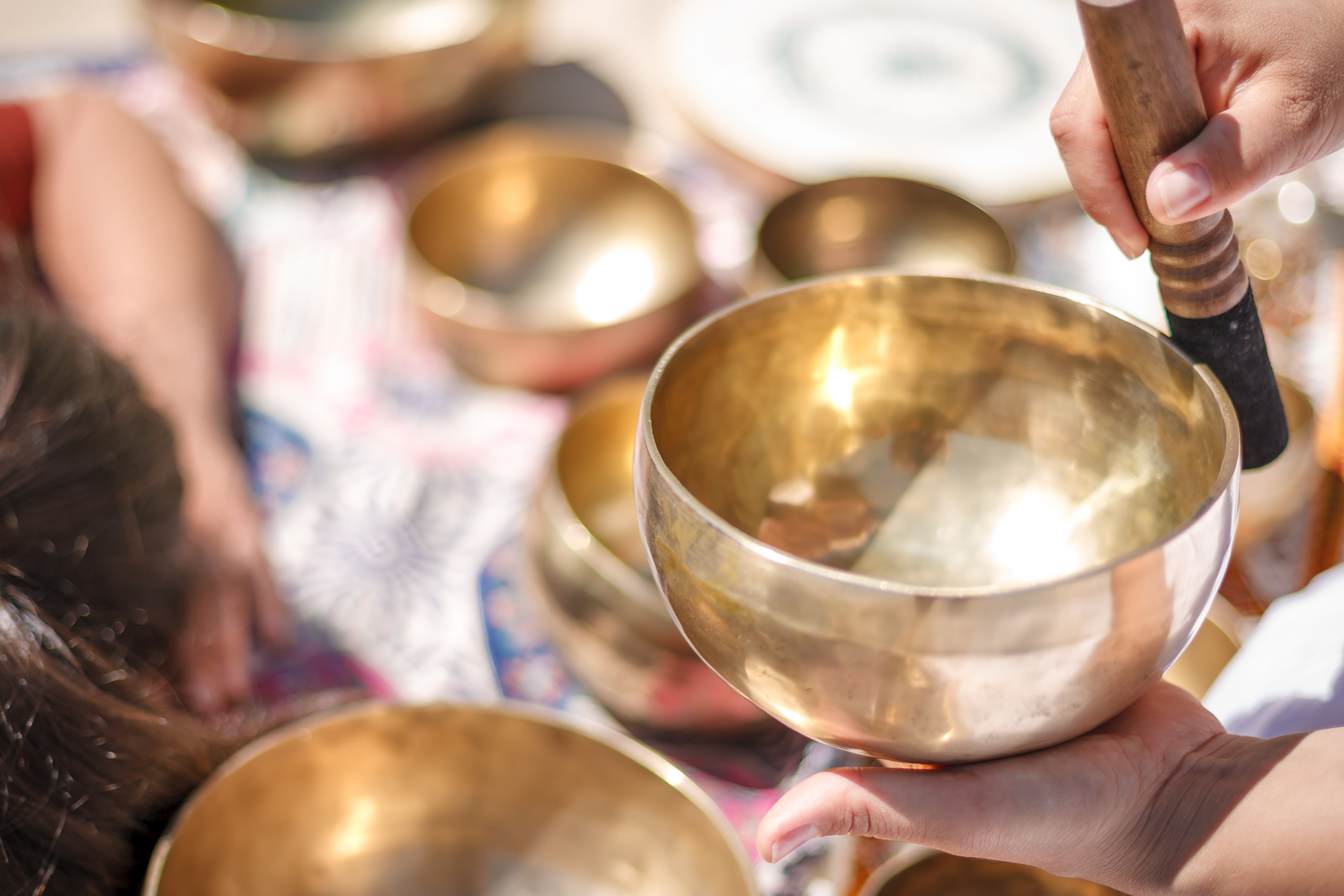 Woman playing a singing bowls also known as Tibetan Singing Bowls