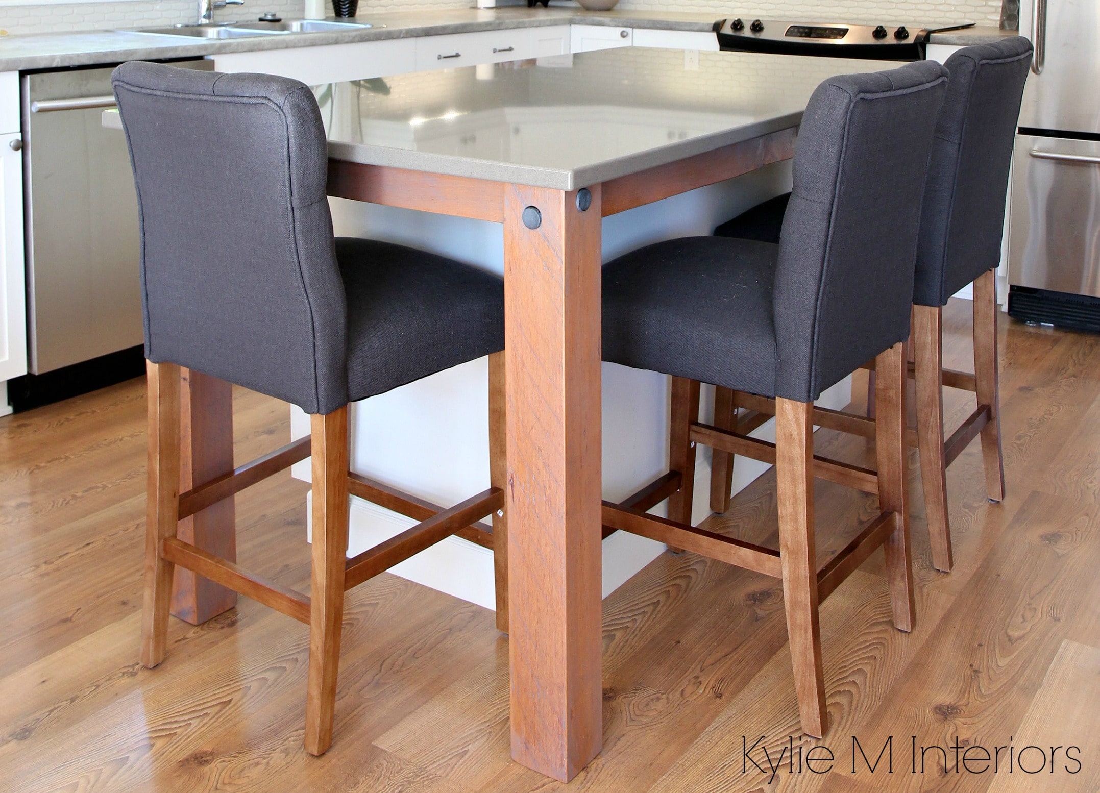Rustic reclaimed legs to support a gray quartz island countertop with