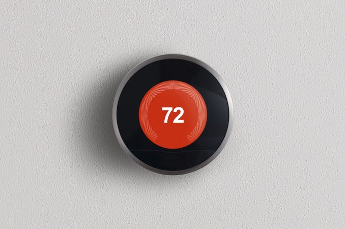 A simplistic photo of a round, modern, programmable digital thermostat